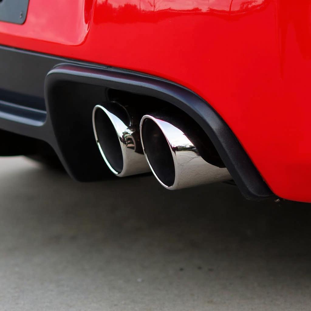 Angled chrome racing muffler tips installed on a sports car