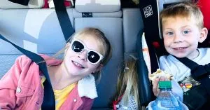 Children in a car packed for a road trip.