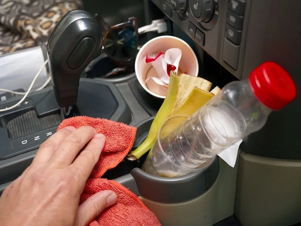 alt text: Person removing trash from car